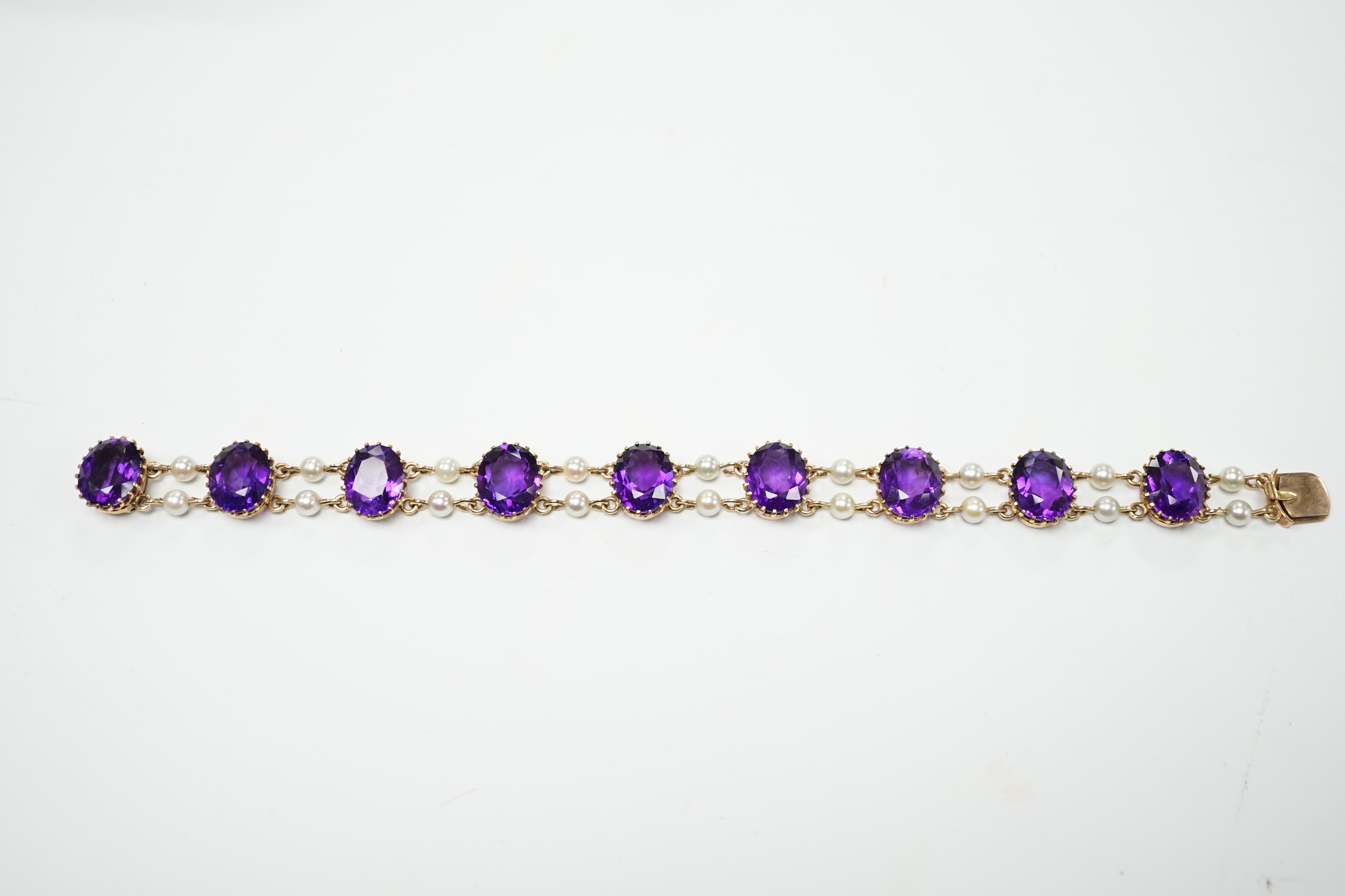 A 1970's Edwardian style 9ct gold amethyst and cultured pearl cluster set bracelet, 17.5cm, gross weight 15.9 grams.